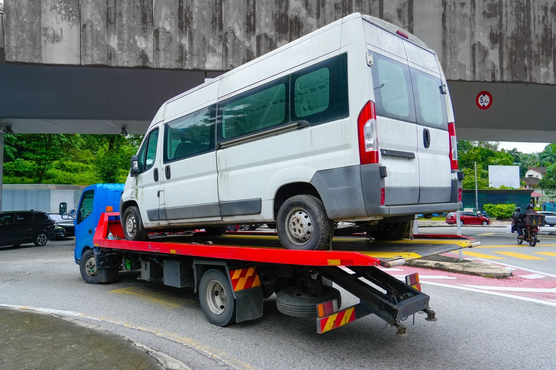 Carriage of a small minibus on the platform tow truck, back view